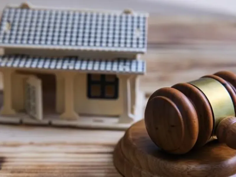 Maqueta de una vivienda junto a un mazo de juez